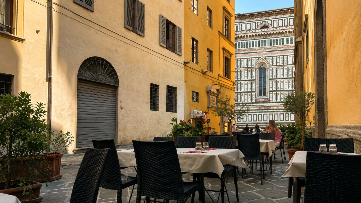 Tavoli all’aperto nel giardino di Osteria Nolarium a Firenze, con vista sulla Cattedrale